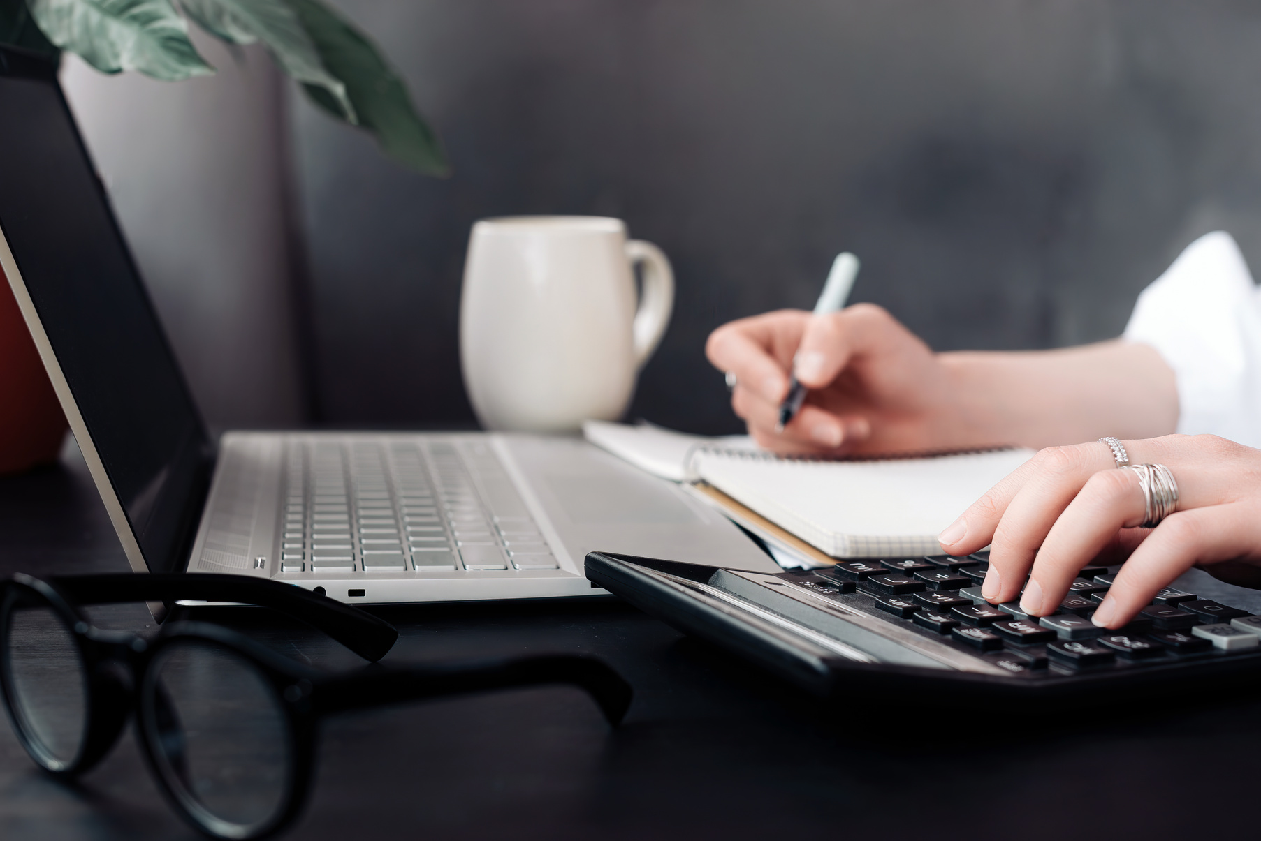 Versatile Financial Expertise. Woman Accountant Uses Calculator and Laptop in Office and While Working from Home, Embracing Finance and Accounting